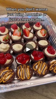 a tray filled with chocolate cupcakes covered in frosting and strawberries on top