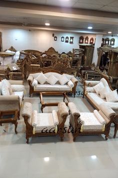 a large room filled with lots of furniture and mirrors on the wall, all covered in white cushions