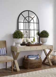 a room with a table, chair and potted plants on the shelf next to it