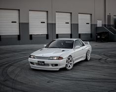 a white car parked in front of some garage doors