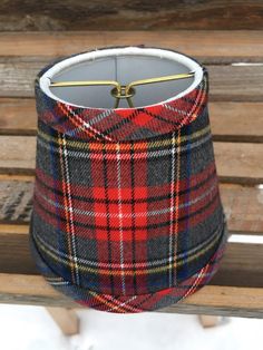 a plaid lamp shade sitting on top of a wooden bench