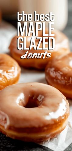 three glazed donuts sitting on top of wax paper