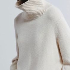 a woman wearing a white turtle neck sweater