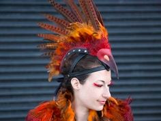 a woman with red and orange feathers on her head