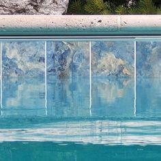 a bird sitting on the edge of a swimming pool