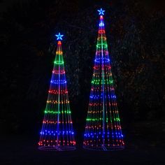 three christmas trees are lit up in different colors and shapes, with stars on them