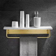 a towel rack with three toothbrushes and two cups sitting on top of it