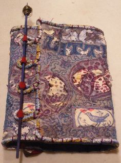 an old book covered in fabric and beads