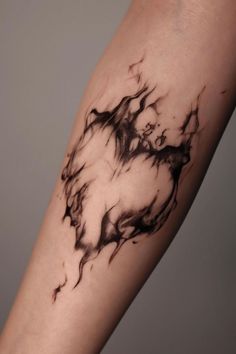 a black and white tattoo design on the left arm, with dark ink swirling over it