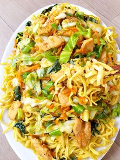 a white plate topped with noodles and chicken