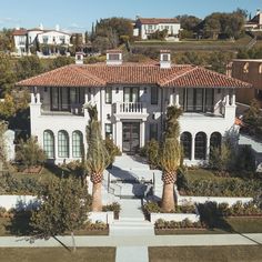 an aerial view of a house with palm trees in the front yard and landscaping around it