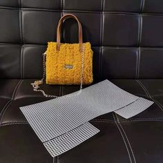 a yellow purse sitting on top of a black couch next to a metal grate