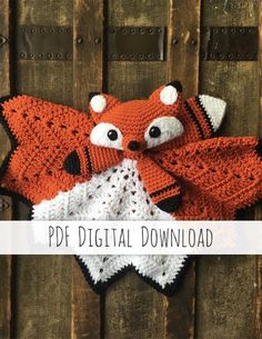 a crocheted fox scarf hanging on a wooden wall