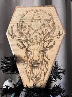 a wooden ornament with an image of a deer's head on it