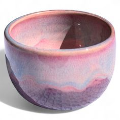 a purple and blue bowl sitting on top of a white table