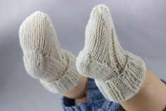 a pair of white knitted mittens sitting on top of a mannequin's head