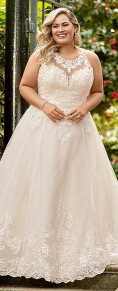 a woman in a wedding dress posing for the camera with her hands on her hips