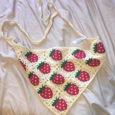 a crocheted triangle with strawberries on it sitting on top of a bed