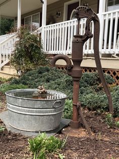 an old fashioned water fountain in front of a house