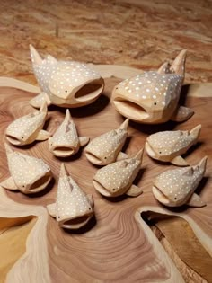 several wooden birds with white polka dots on them sitting on a wood table next to each other