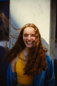 a woman with long red hair smiling at the camera