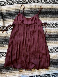 Free People slip dress.  Babydoll fit with adjustable shoulder straps. Ties on each side at bra line. Color is a deep burgundy. Suspender Dress With Spaghetti Straps For Brunch, Brunch Suspender Dress With Adjustable Spaghetti Straps, Brunch Suspender Dress With Spaghetti Straps, Fitted Slip Dress With Tie Straps For Vacation, Cami Slip Dress With Adjustable Straps For Date Night, Vacation Slip Dress With Tie Straps, Vacation Slip Dress With Spaghetti Straps And Tie Back, Sundress Suspender Dress With Adjustable Straps For Date Night, Date Night Sundress With Adjustable Straps