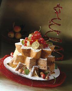 a cake made out of bread and fruit on a red plate with other food items