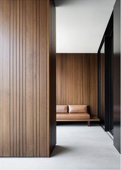 a room with wood paneling on the walls and a couch in the corner next to it