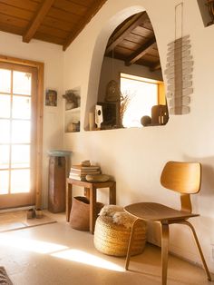 a chair and table in a room with wooden ceiling beams on either side of the wall