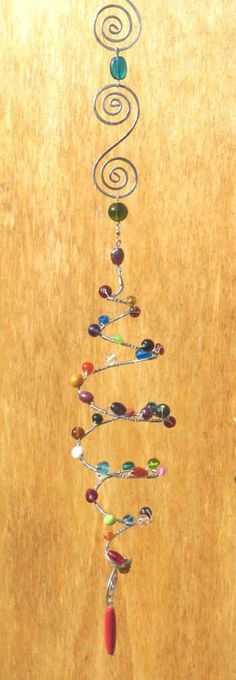 a tree made out of glass beads on top of a wooden table next to a wall