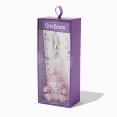 a purple bear keychain in a box on a white background with the words care bears printed on it