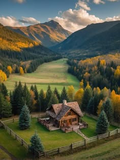 an aerial view of a house in the mountains with trees around it and grass on the ground