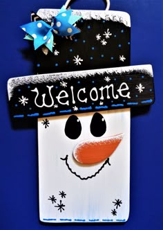 a welcome sign with a snowman's face on it and a blue background