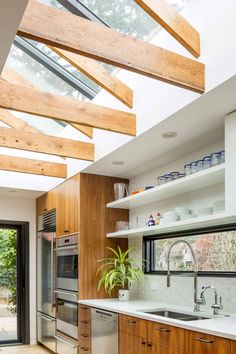 an open kitchen with wooden cabinets and white counter tops is featured in this modern home