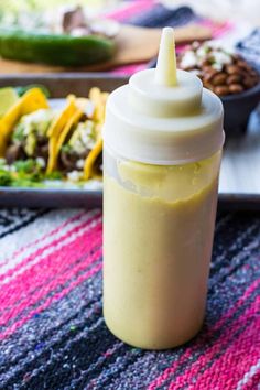 a baby bottle sitting on top of a table next to a plate with food in it