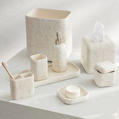 a bathroom set consisting of soap dispenser, toothbrush holder and tissue dispenser