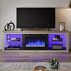 a living room with a large television and fire place in front of the flat screen tv