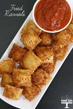 fried ravioli on a plate with dipping sauce