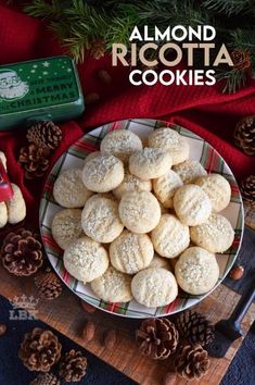 almond ricotta cookies are on a plate next to pine cones and christmas tree decorations