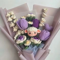 there is a stuffed animal in the middle of some crocheted flowers and leaves