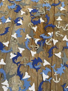 blue and white confetti shaped like sharks on wooden planks with anchor in the middle