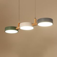 three circular lights hanging from the ceiling in a room with beige walls and flooring