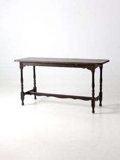 an old wooden table sitting on top of a white floor