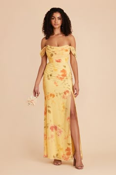 a woman wearing a yellow floral print dress with thigh high slits and an off - the - shoulder top