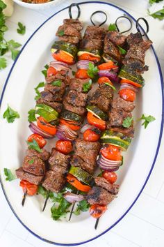 several skewers of meat and vegetables on a plate