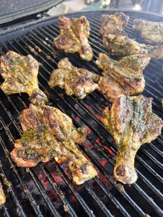 several pieces of meat cooking on a grill