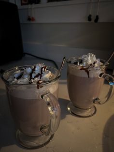 two mugs filled with hot chocolate and whipped cream