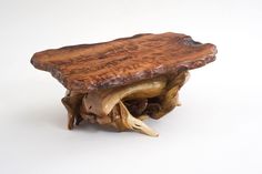 a piece of wood sitting on top of a wooden table next to a white wall