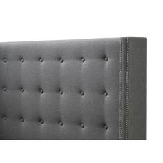 an upholstered gray headboard with buttons and nail holes on the back side