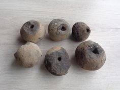 five rocks are arranged in a circle on a white table top, with holes in the middle